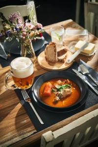 a table with a plate of food and a glass of beer at Hotel Popel in Stachy