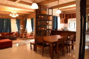 a dining room and living room with a table and chairs at Mrëmbo Boutik Hôtel in Ruhengeri