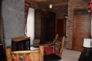 a living room with chairs and a brick wall at Mrëmbo Boutik Hôtel in Ruhengeri