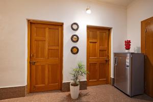 a kitchen with two wooden doors and a refrigerator at Adviga by The StayCationer in Dehradun