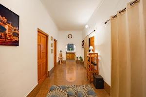 a hallway with white walls and a clock on the wall at Adviga by The StayCationer in Dehradun