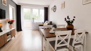 a kitchen and living room with a table and chairs at Albatros Apartment Stogi in Gdańsk