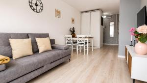a living room with a gray couch and a table at Albatros Apartment Stogi in Gdańsk