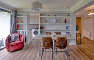 a kitchen with a dining table and a red chair at Finest Retreats - Gleneagles in Auchterarder