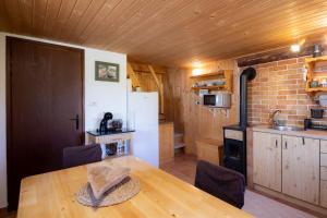 a kitchen with a wooden table and a white refrigerator at Hiška Janko in Bohinjska Bistrica