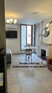 a living room with a table and a fireplace at Le Petit Bijou Sète, 5 appartements in Sète