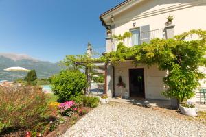 a house with a garden and a driveway at Foresteria Villa Margherita in Colico