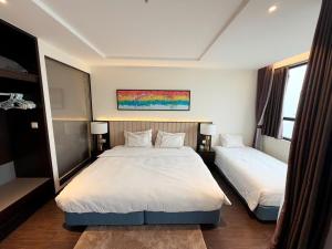 a bedroom with two beds and a painting on the wall at Sapphire Hạ Long Luxury Studio in Ha Long +2 photos