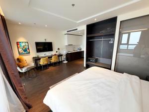 a bedroom with a bed and a living room with a desk at Sapphire Hạ Long Luxury Studio in Ha Long