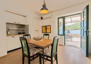 a kitchen and dining room with a wooden table and chairs at Seafront Stone House Maxim in Tivat +21 photos