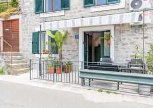 a green bench in front of a building at Seafront Stone House Maxim in Tivat