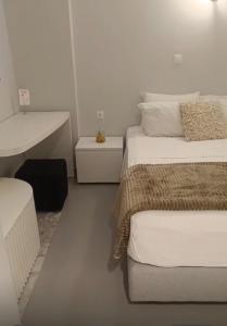 a white bedroom with two beds and a sink at Zen Townhouse - Infinity Seaview in Palaiokastro