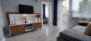 a living room with a flat screen tv on a cabinet at Albatros Apartment Stogi in Gdańsk