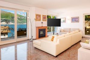 a living room with two white couches and a fireplace at Villa Incanto Adults Only in Brenzone sul Garda