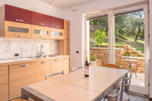 a kitchen with a table with two wine glasses on it at Villa Incanto Adults Only in Brenzone sul Garda