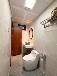 a bathroom with a white toilet and a sink at Gasu home in Ninh Binh