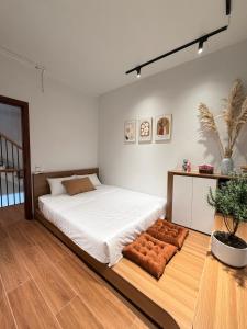 a bedroom with a large white bed with brown cushions at Gasu home in Ninh Binh