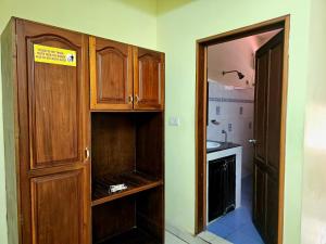 a kitchen with wooden cabinets and a sink at PTC Residency in Alleppey
