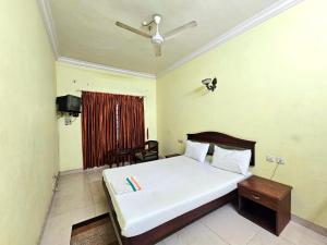 a bedroom with a bed and a table and a window at PTC Residency in Alleppey