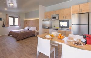 a room with a bed and a kitchen with a table at Rubina Resort in Empuriabrava