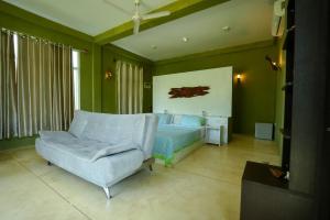 a living room with a couch and a couch and a chair at Singhe House in Dickwella