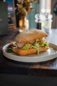 a sandwich on a white plate on a table at The Huntsman in Norwich