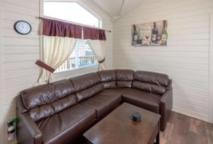 a living room with a brown leather couch and a table at 49er Village in Plymouth