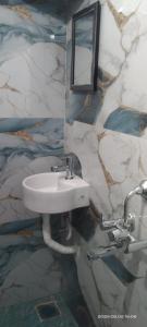 a white sink in a bathroom with a marble wall at SIU Elite INN in Chennai