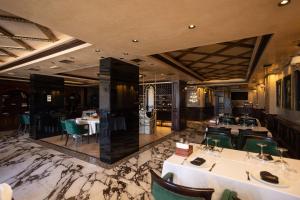 ein Esszimmer mit Tischen und grünen Stühlen in der Unterkunft Hotel Chicago in Shkodra