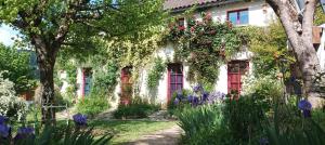 a house with flowers on the side of it at Paysannerie des Versanes - Chambre et gîte à la ferme in Tour-de-Faure