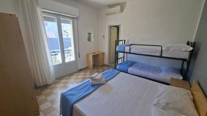 two bunk beds in a room with a window at Hotel Astoria in Riccione