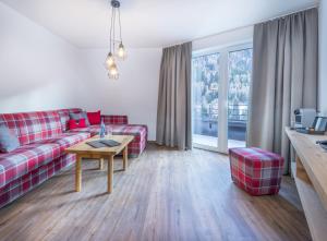 a living room with a red couch and a table at Heart Hotel Grischuna in Sankt Anton am Arlberg