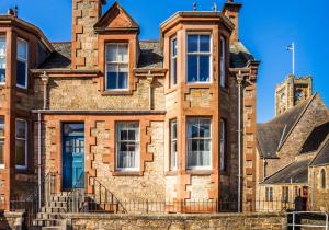 an old brick building with a blue sky in the background at The Neuk in North Berwick
