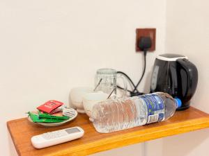 a bottle of water on a wooden shelf with a coffee maker at Arugam Bay Resort in Arugam Bay