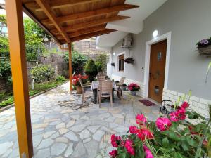 a patio with a table and chairs and flowers at Artur's Apartment in Gjirokastër