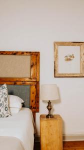 a bedroom with a bed and a table with a lamp at Cottage 1 at River Bend in Graaff-Reinet +8 photos