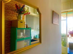 a mirror on a wall with a green cabinet in a kitchen at Accogliente stanzetta vicina al centro di Torino in Turin +17 photos