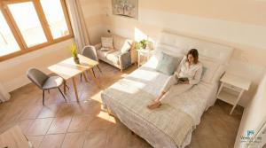a woman sitting on a bed in a room at The Sea Wind Apartments & Suites in Palau