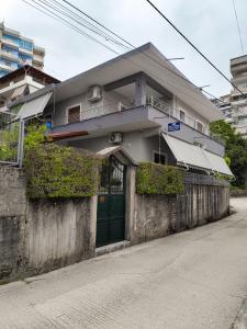a building with a green door on the side of a street at Artur's Apartment in Gjirokastër +6 photos