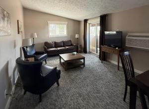 a living room with a couch and a tv at Mushroom Cap Motel in Mesick