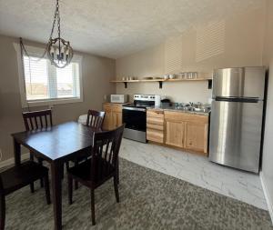 a kitchen with a table and a stainless steel refrigerator at Mushroom Cap Motel in Mesick