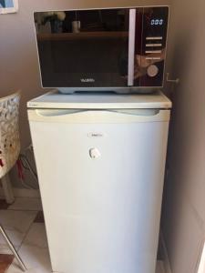 a microwave sitting on top of a white refrigerator at Le Petit Château - Cannes in Cannes