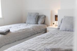 two beds sitting next to each other in a bedroom at Large, Bright 4 Bed Home with Garden in Kenton
