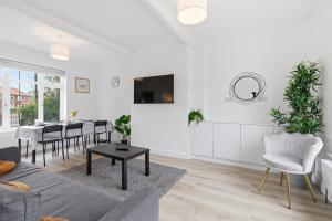 a living room with a couch and a table at Large, Bright 4 Bed Home with Garden in Kenton