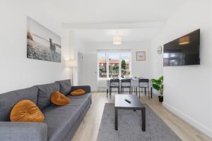 a living room with a couch and a table at Large, Bright 4 Bed Home with Garden in Kenton +29 photos