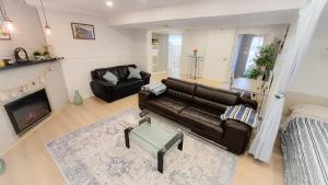 a living room with a leather couch and a fireplace at Applewood Gardens Apartment in Mississauga