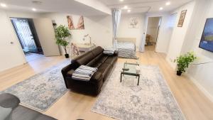 a living room with a leather couch and a table at Applewood Gardens Apartment in Mississauga