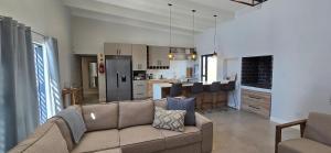 a living room with a couch and a kitchen at Sky & Sea in St. Helena Bay