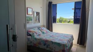 a small bed in a room with a window at Flat Bela Amarração in Luis Correia