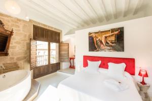 a bedroom with a large white bed and a bath tub at Teatrisso Hotel Palacio in Cuzcurrita-Río Tirón